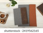 Small photo of Leather and fabric flap portfolio. Concept shot, top view, flap portfolio in different colors and leather pen. Custom background flap portfolio view. Flap portfolio and accessories.