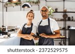 Small photo of Two hospitality entrepreneurs standing in their small coffee shop. Successful man and woman working as a team to manage the day-to-day operations and provide excellent service to their customers.