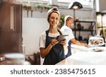 Small photo of Coffee shop manager efficiently managing her business with the help of a digital tablet. Woman using a touchscreen device to keep track of inventory, update menus, and manage orders with ease.