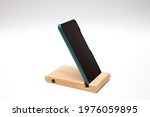 Smartphone in a wooden stand on the table.