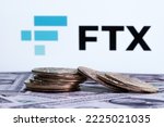 Small photo of FTX bankruptcy and collapse. Cryptocurrency Exchange bankrupt company concept. Stack of fallen bitcoins on dollars and FTX logo seen on display. Stafford, United Kingdom, November 10, 2022.