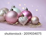 Small photo of Christmas decorations in pastel colors. Christmas background. delicate colors. pink, purple, lilac, white glamour color, light tones. yappy new year. bulb, toys