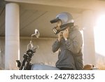 A biker puts on a helmet while...
