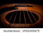 Guitar.Guitar's chords.Acoustic guitar.Music.Music background.Image of an acoustic guitar in the dark.Playing music with some friends in the dark.Classical music.Closeup image of an acoustic guitar.