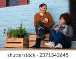 Happy brazilian adult daughter and mother sitting and relaxing and enjoying outside the house. Unity, happiness, affection, love, care concept.
