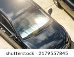 Protective reflective surface under the windshield of the passenger black car parked on a hot day, heated by the sun's rays inside the car