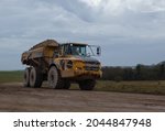 yellow Volvo A40E articulated dump truck earth mover with 25 tonne payload driving across Salisbury Plain, Wiltshire UK