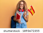 Beautiful caucasian teenager girl exchange student holding spanish flag smiling with a happy and cool smile on face. showing teeth. 