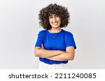 Young middle eastern woman standing over isolated background happy face smiling with crossed arms looking at the camera. positive person. 