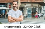 Small photo of Middle age man standing with arms crossed gesture at street