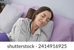 Small photo of Exhausted, yet beautiful young hispanic woman lying asleep in freshly made bed, surrendering to slumber's embrace in her cozy room, a spectacular indoor sanctum of rest and relaxation