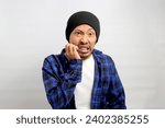 Small photo of Frightened young Asian man nervously bites his fingernails, gazing anxiously at the camera, visibly perturbed by something scary, experiencing a mix of anxiety, horror, and concern, white background