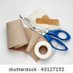 Small photo of Gauze, ace bandage, tape, scissors and bandages shot on white background with a soft shadow