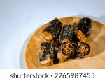 Fried samyang with seaweed skin rolls arranged on a wooden cutting board with a plain white background