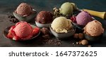 Gourmet summer dessert of artisanal or craft ice cream made with fresh berries, macaroons, coffee beans, pistachio nuts and chocolate served in bowls in a wide angle banner