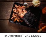 Aerial Shot of Mouth Watering Pulled Pork Dish on Black Serving Tray with Fork. Served on Wooden Table.