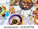 Overhead Well Laid summer table with colorful dish and plates and brazier on white background with vegan bbq skewers