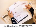 Small photo of An accountant looks at debt envelopes as a concept of growing delinquent debts, rising prices, and declining incomes.