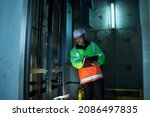 Small photo of People in elevator shaft. service engineer checking inspector part of elevator. worker check in lift shaft.