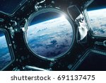 Porthole of space station near the Earth on the background. Elements of this image furnished by NASA