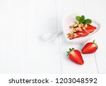 Bowl  with strawberry yogurt on a white wooden table