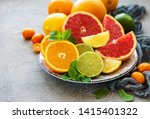 Plate with citrus fresh fruits on a concrete background