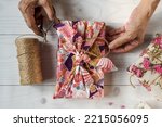 Eco-friendly gift cloth wrapping in Furoshiki style, reusable sustainable recycled textile gift wrapping, zero waste concept. Copy space 

