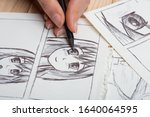 Artist drawing an anime comic book in a studio.