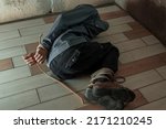 Small photo of an unrecognizable man in a hood is captured in the basement bound by a rope hand and foot . The kidnapped man is tied up, sitting in the basement. Hands and feet are tied with rope. lying on the floor