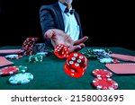 Gambling concept. Close up of Poker Player male hand throwing dice at casino, gambling club. Сasino chips or Casino tokens, poker cards, gambling man lucky guy spending time in games of chance.