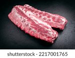 Small photo of Raw pork spare loin ribs St Louis cut offered as closeup on black background with copy space