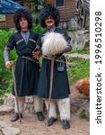 Small photo of Batumi, Georgia, 08.07.2019, Two man in Georgian costumes near Tamara Bridge