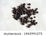 Small photo of Allspice grains lying on a ceramic plate. Allspice, also known as Jamaica pepper, myrtle pepper, pimenta, or pimento. Allspice is one of the most important ingredients of Caribbean cuisine.