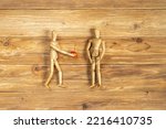 Small photo of wooden mannequins as Adam and Eve seducing one another with offer