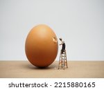 Miniature at table and egg with white background.