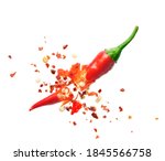 Chili flakes bursting out from red chili pepper over white background