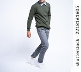 Man wearing sweater green and shirt with grey chinos and white shoes