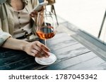 Well dressed woman holding glass with rose wine and using mobile phone