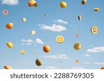 Summer fruit flying in the sky. Citrus fruit surreal floating concept. Orange, grapefruit, kiwi, lemon fruit with clouds.