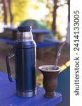 Small photo of mate and thermos, Argentine drink based on yerba mate with hot water, sharing mate in a natural environment with many plants and trees, breathing fresh air.