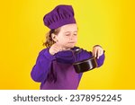 Small photo of Kid chef cook with cooking pot stockpot. Portrait of little child in uniform of cook. Chef boy isolated on studio background. Cute child to be a chef. Child dressed as a chef hat.