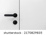 Element of interior design. Close up view of black handle with lock on entrance door in living room or bedroom. Selective focus on latch and doorknob in apartment, close to white copy space wall