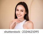 Small photo of studio shot of young smiling woman with healthy radiant skin looking at camera and touching her chin. eyebrow lamination, skincare concept