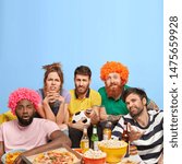 Small photo of Unhappy four men and one woman dissatisfied with final result of football match, upset favourite team lost game, surrounded with tasty pizza, popcorn, burgers and chips, gather together at home