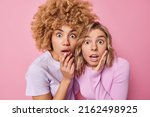 Small photo of Two shocked women friends stare impressed or startled at camera feel concerned gasp from wonder and fear dressed casually stand next to each other isolated over pink background. Omg concept.
