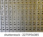 A wall of mail boxes inside of a post office.