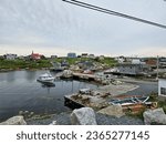 Small photo of Peggy's Cove, NS, CAN, August 15, 2023 - A view of the houses on a hill along the water at Peggy's Cove, Nova Scotia with boats docked at the wharf beneath them.
