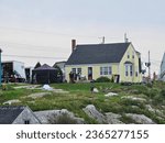 Small photo of Peggy's Cove, NS, CAN, August 15, 2023 - A film crew setup outside of an old yellow home in Peggy's Cove, Nova Scotia on a cloudy summer morning.