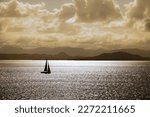 Sailboat silhouette in warm sunlight 