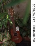 Small photo of Close up Ukulele ,classical instrument, with flowers. Ukulele sound is relax. Ukulele is beautiful.